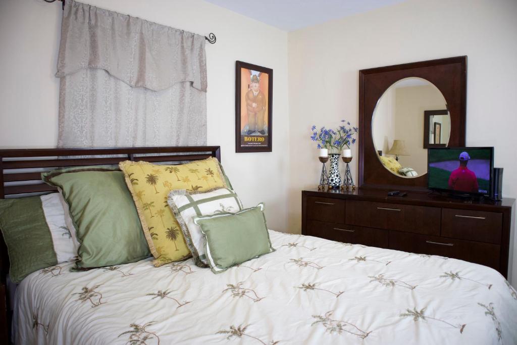 a bedroom with a bed with pillows and a mirror at Great Location near Downtown & Airport in Tampa