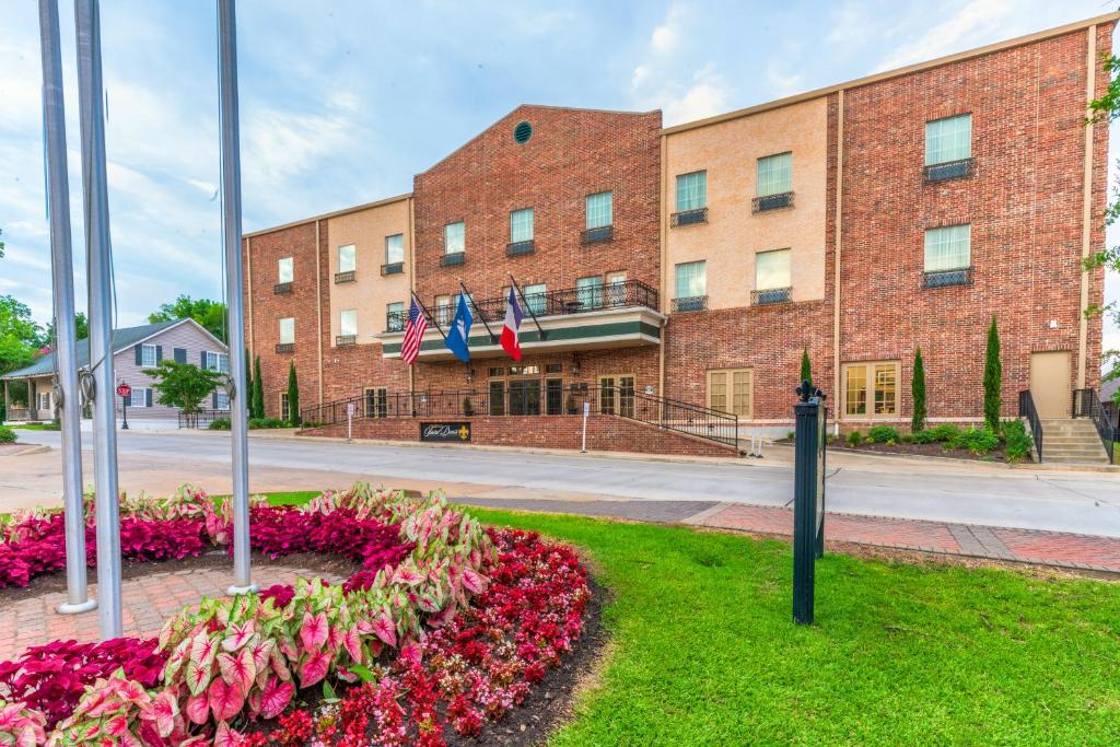 Un edificio con un mazzo di fiori davanti di Chateau Saint Denis a Historic Hotel Downtown Natchitoches a Natchitoches