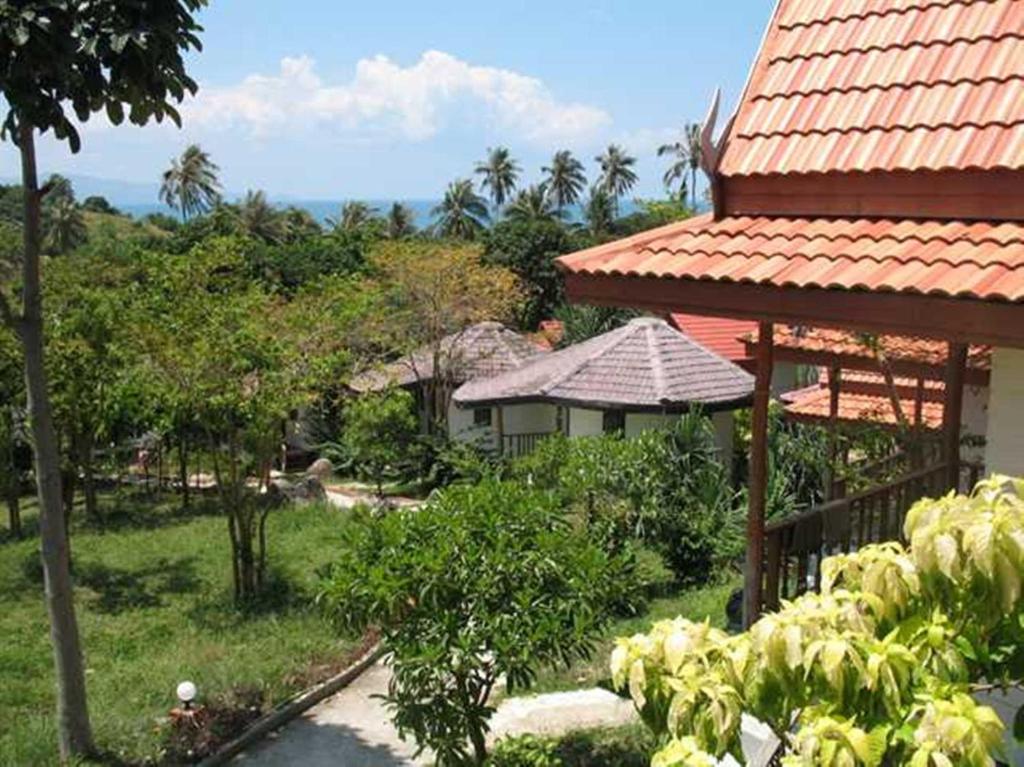 una casa con techo rojo y jardín en Thai Dee Garden Resort, en Haad Rin