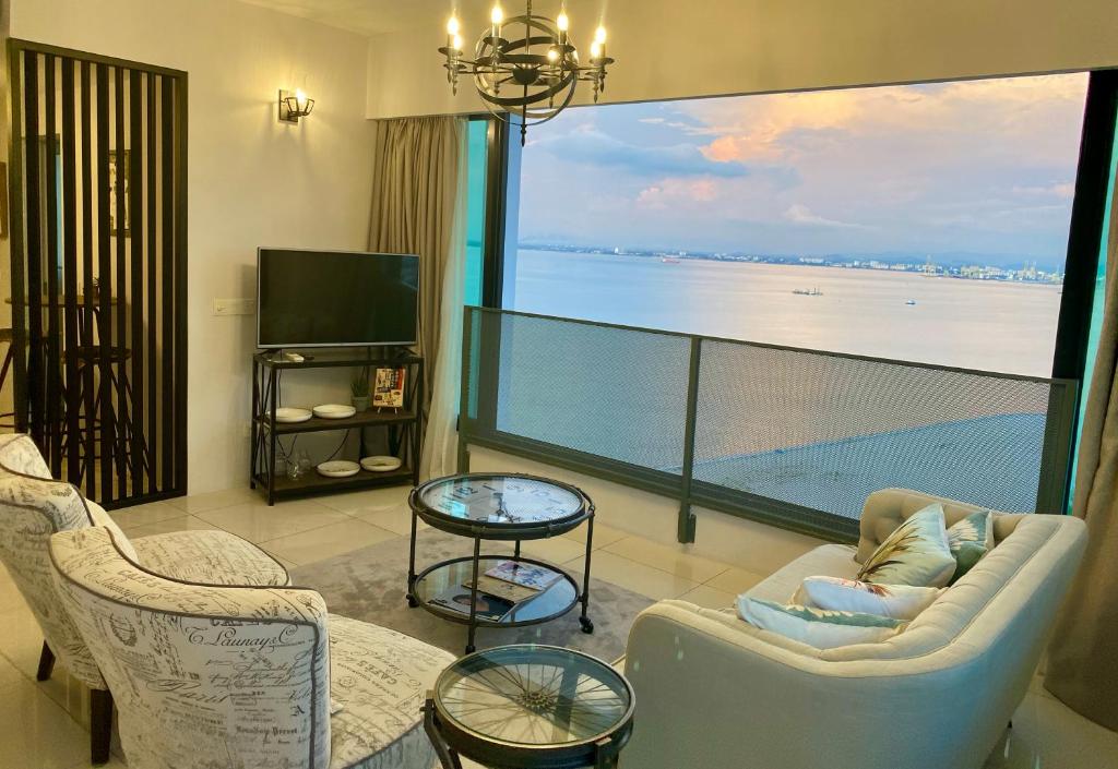 a living room with a large window with a view of the ocean at SUNRISE Gurney Seaview Luxury Duplex in George Town