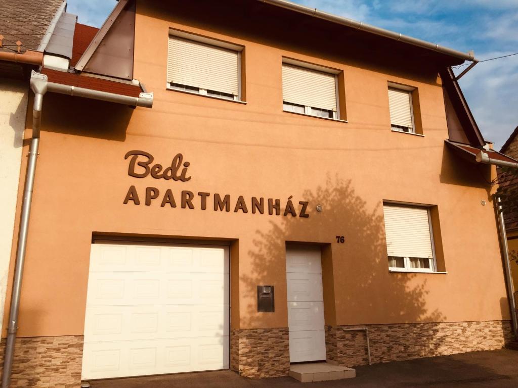 a building with two garage doors in front of it at Bedi Apartmanház in Nagykanizsa