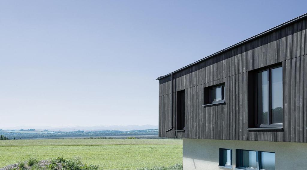 een zwart gebouw met ramen aan de zijkant bij Chalet am Ried in Bad Wurzach