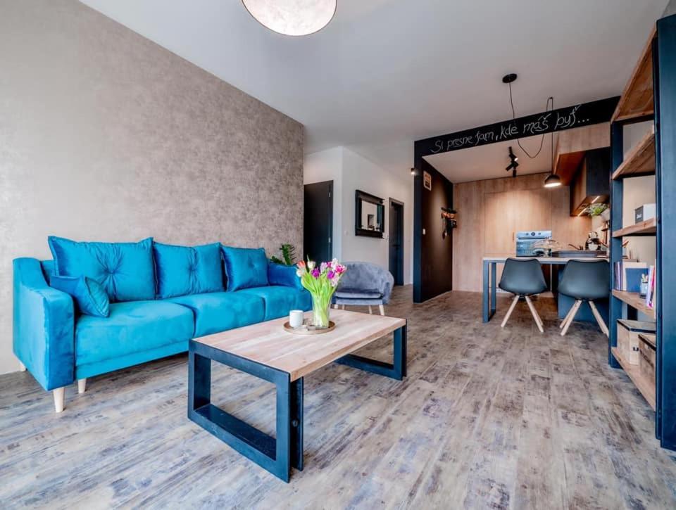 a living room with a blue couch and a table at B10 Business Apartments in Žilina