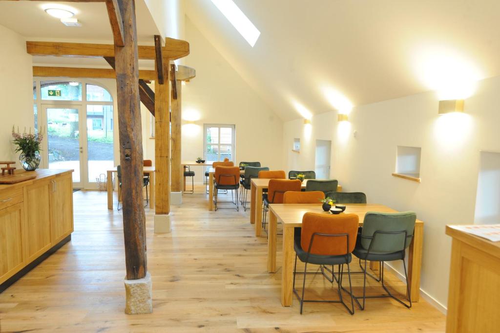 uma sala de jantar com mesas e cadeiras de madeira em Blekkers Bed&Breakfast em Uelsen