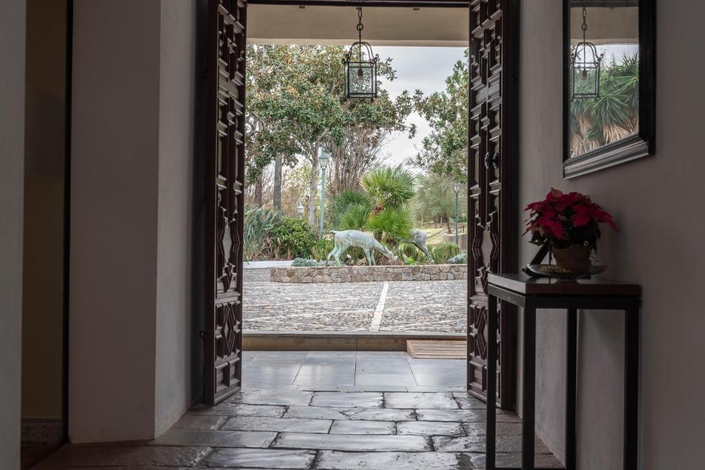 a hallway with an open door with a dog in the yard at La Almoraima Hotel in Castellar de la Frontera