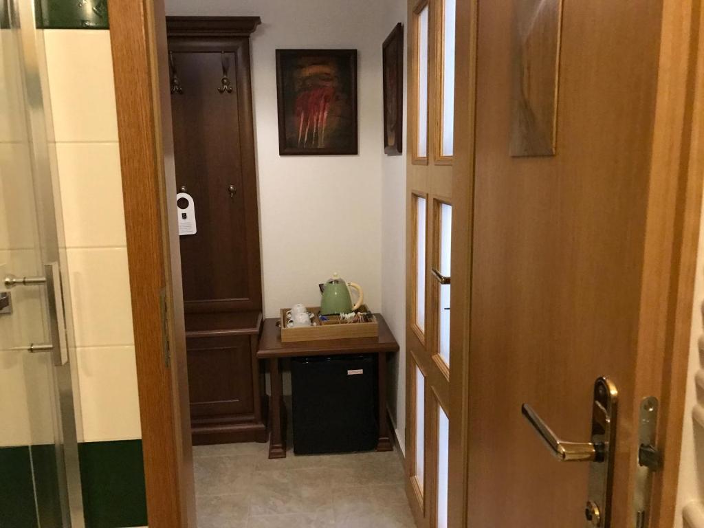 a bathroom with a hallway with a table and a door at Antik Hotel Sofia in Litomyšl