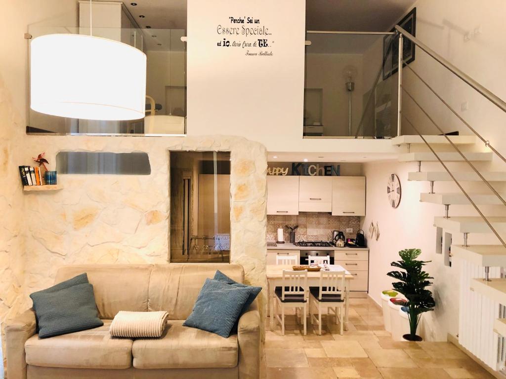 een woonkamer met een bank en een keuken bij SPAZIO M&M Cso XXII MARZO 39 in Milaan