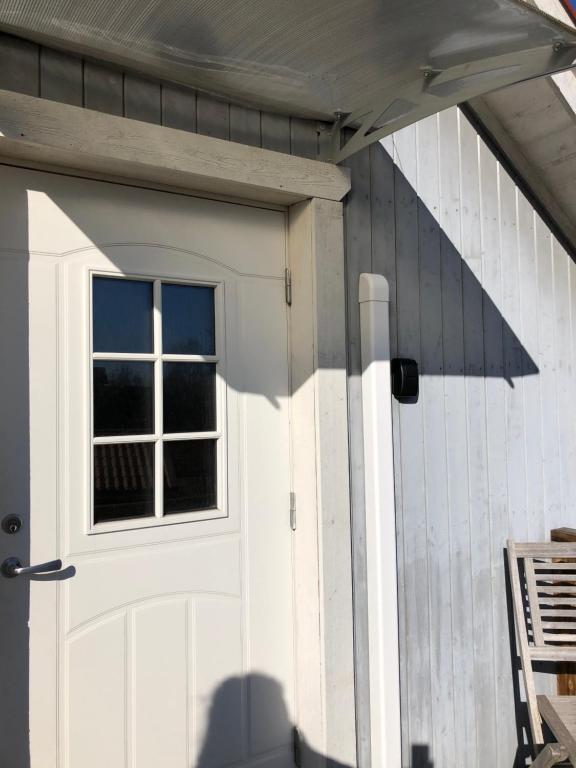 une porte de garage blanche avec une fenêtre sur une maison dans l'établissement Loftet, à Insjön