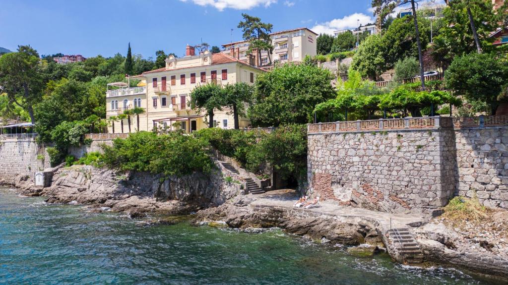 rzeka z budynkami na zboczu wzgórza w obiekcie Seaside Apartment Volosko on the beach w mieście Opatija