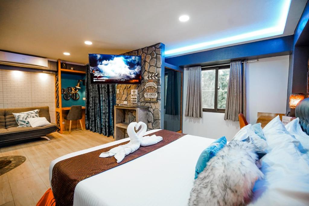a hotel room with a bed and a flat screen tv at CLOCKWORKORANGE Luxury Suites in Mactan