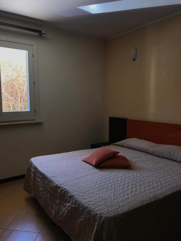 a bedroom with a bed with two pillows on it at Castellammare Smart Rooms in Castellammare del Golfo