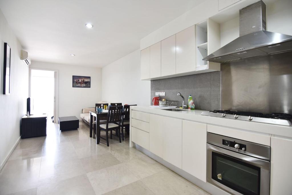 a kitchen with white cabinets and a table in it at COZY 2BR Fairlane Residences Next To Lot 10 in Kuala Lumpur