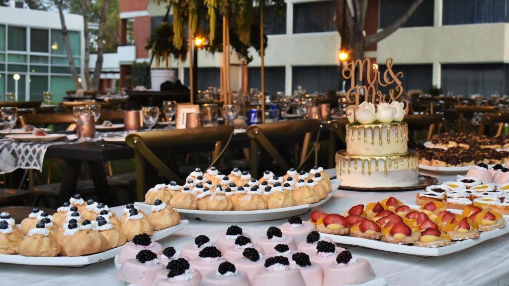 a table topped with different types of cakes and pastries at Holiday Inn San Luis Potosi-Quijote by IHG in San Luis Potosí