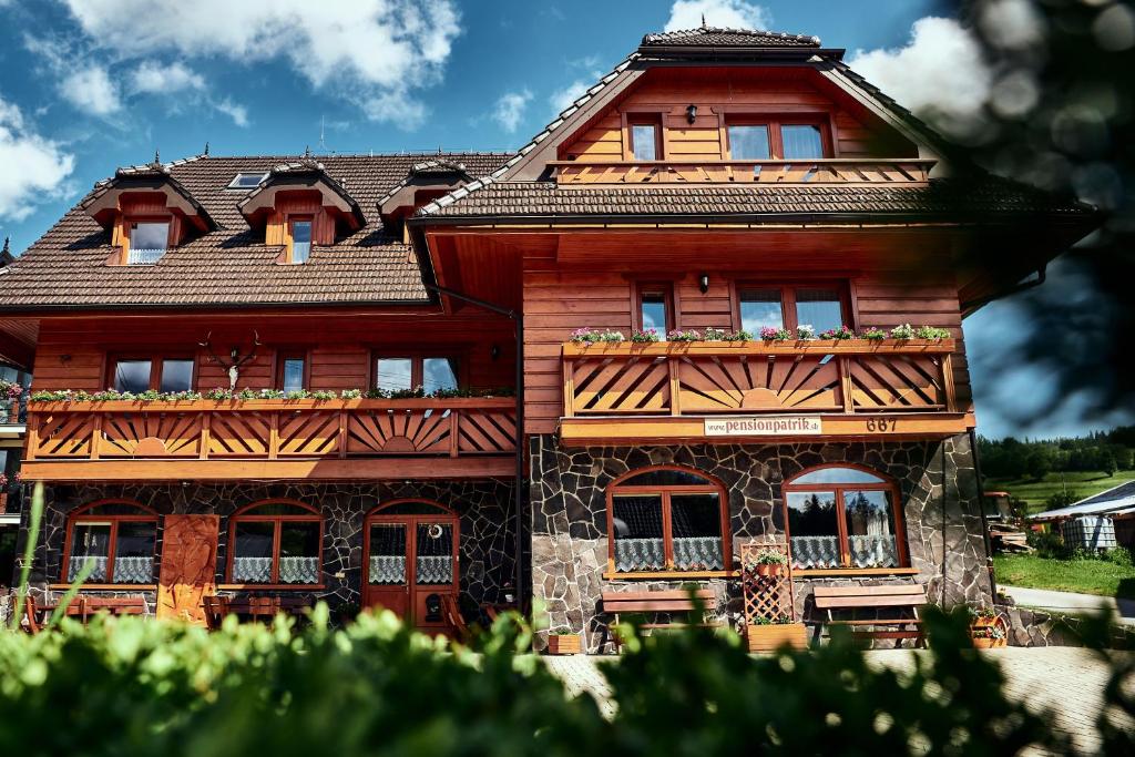 ein Holzhaus mit Fenstern und einem Dach in der Unterkunft Penzión Patrik in Ždiar