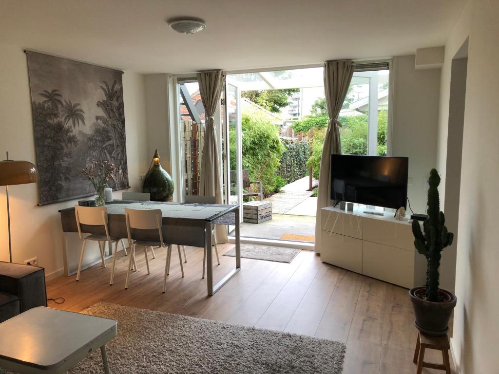 a living room with a dining table and a television at Savina City Centre Apartment Near Beach, Station and Shops in Zandvoort