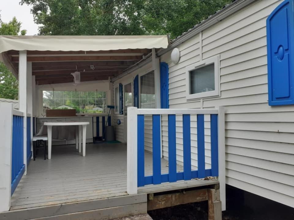 a porch of a house with a blue and white deck at Mobilhome in Les Mathes