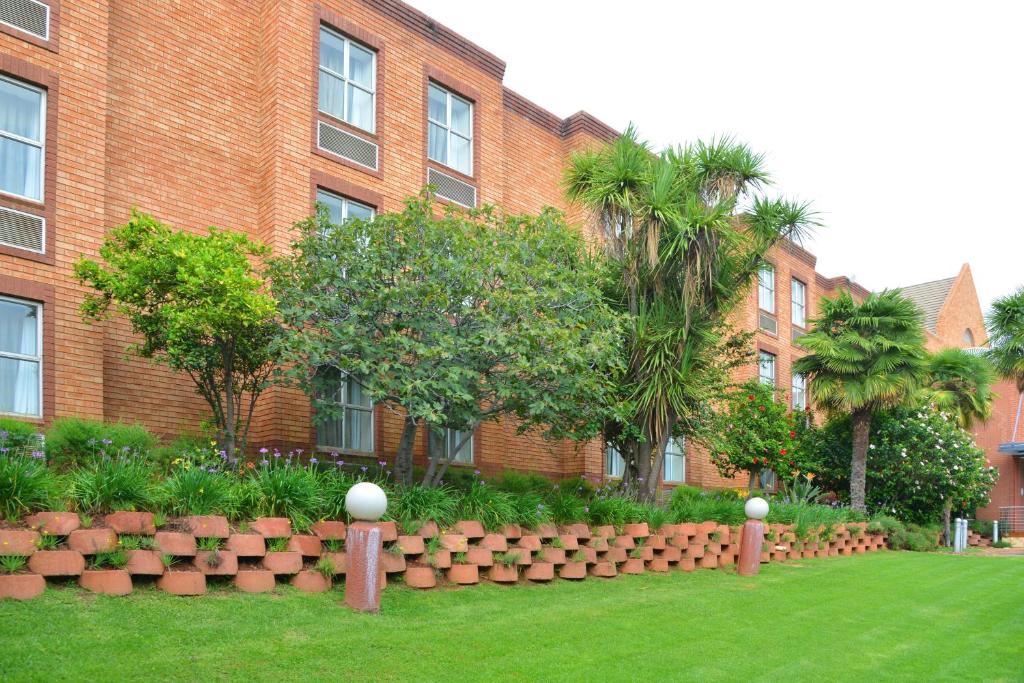 - un bâtiment en briques avec un jardin en face dans l'établissement Road Lodge Sandton, à Johannesbourg