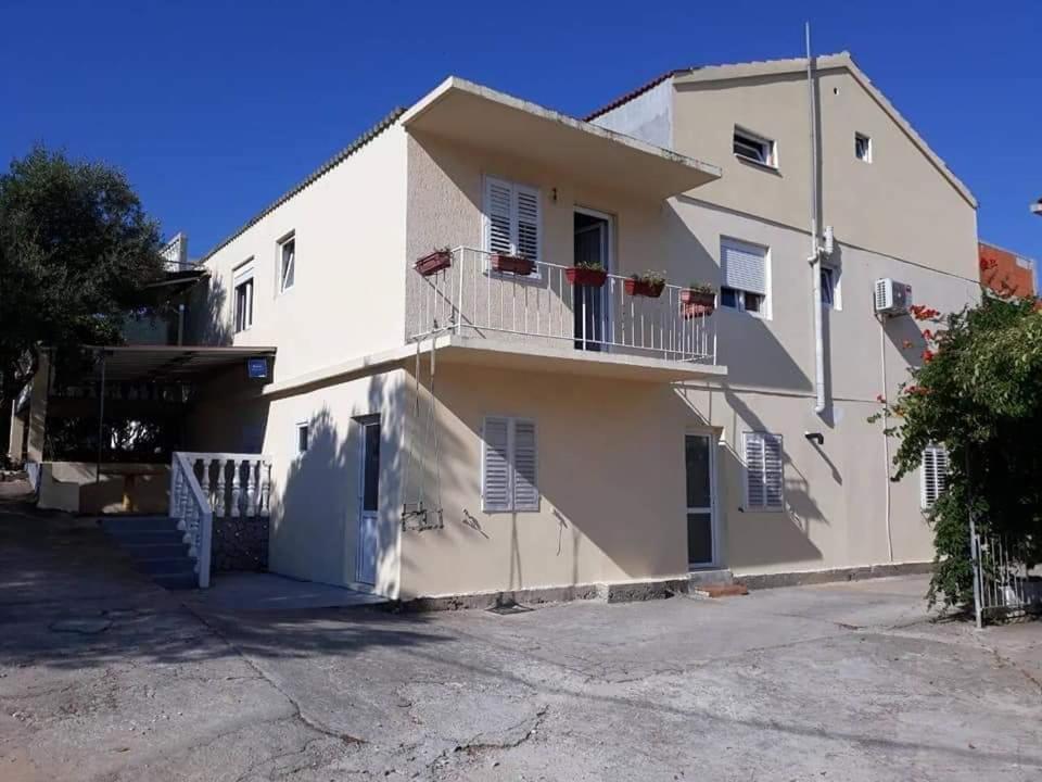 a white building with stairs and balconies on it at Apartmani Bezek in Ston