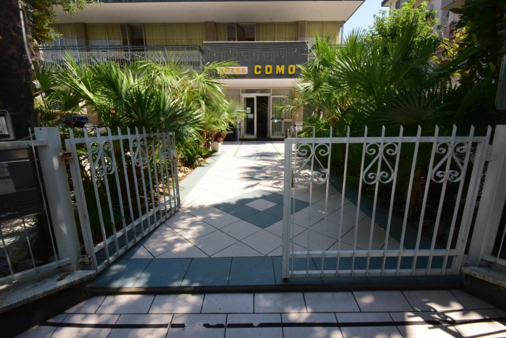 une porte blanche devant un bâtiment avec des plantes dans l'établissement Hotel Como, à Rimini