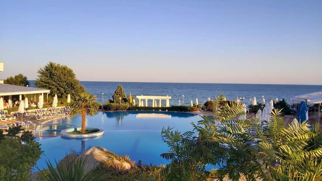 une grande piscine avec l'océan en arrière-plan dans l'établissement Sineva Beach Hotel - All Inclusive, à Sveti Vlas