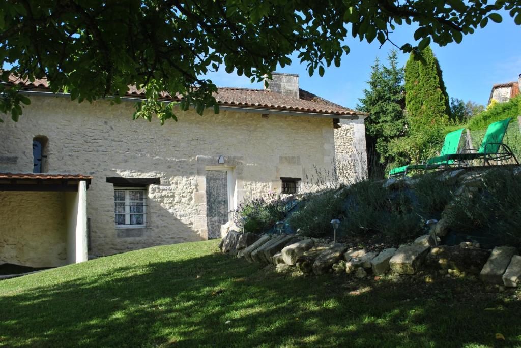 a stone house with a grassy yard in front of it at Maison Belle Vue in Cherval
