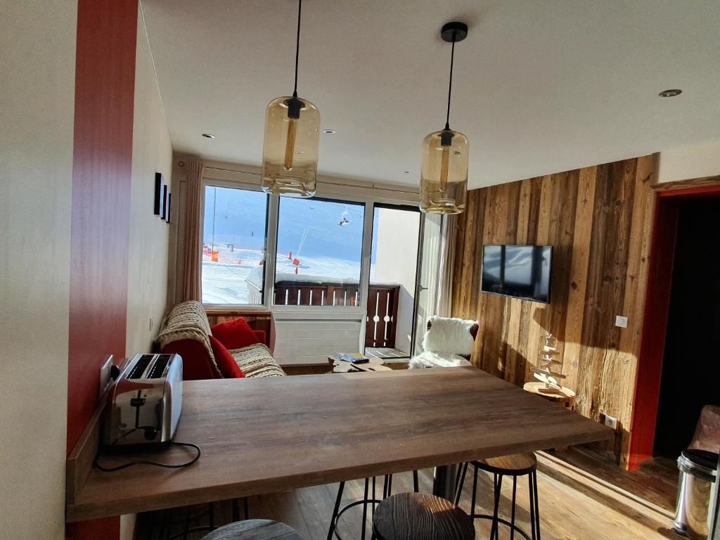 un soggiorno con tavolo e vista sulla spiaggia di L'Olympic - T2 - Pied des pistes - 40 m2 - WIFI a Val Thorens