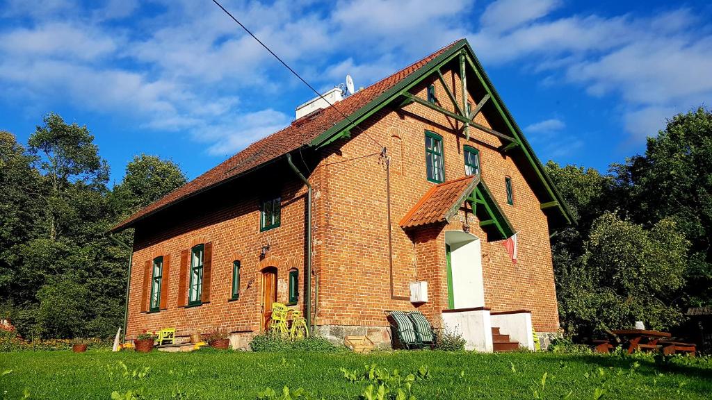 un viejo edificio de ladrillo en un campo de hierba en Gajówka en Węgorzewo