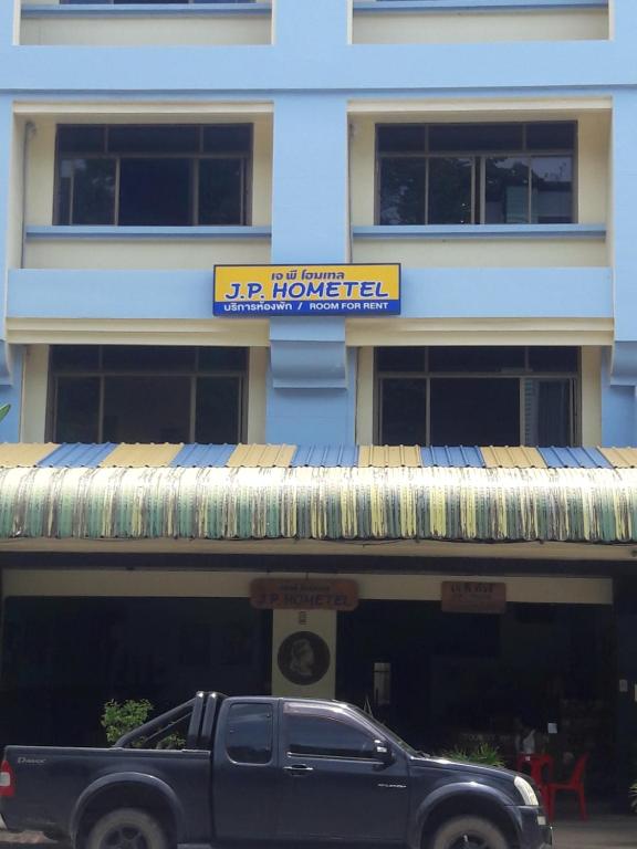 a black truck parked in front of a building at JP hometel in Krabi