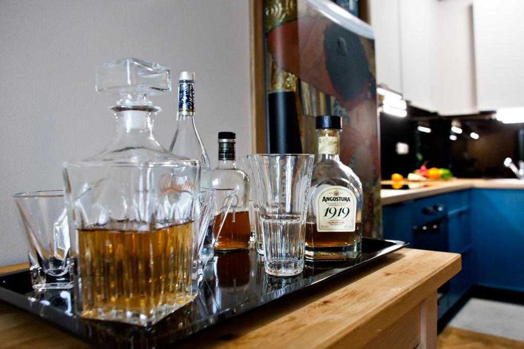 ワルシャワにあるOCHOTA P&O Serviced Apartmentsのカウンターにアルコールボトルとグラスを用意したトレイ