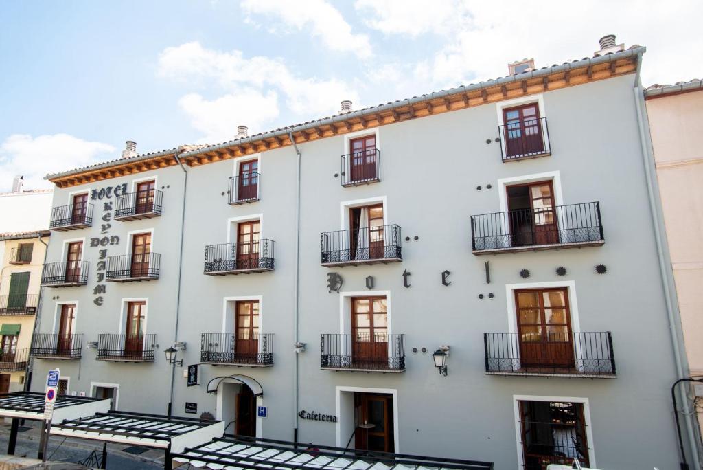 - un bâtiment blanc avec des fenêtres et des balcons dans l'établissement Hotel Rey Don Jaime, à Morella