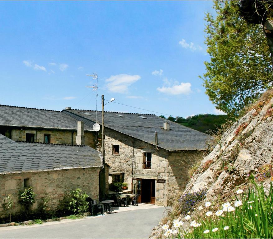 un antiguo edificio de piedra con una entrada delante de él en Casa Morgade en Sarria