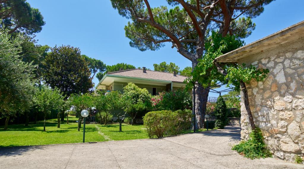 a house with a stone wall next to a driveway at Villa Luisa B&B in Sperlonga