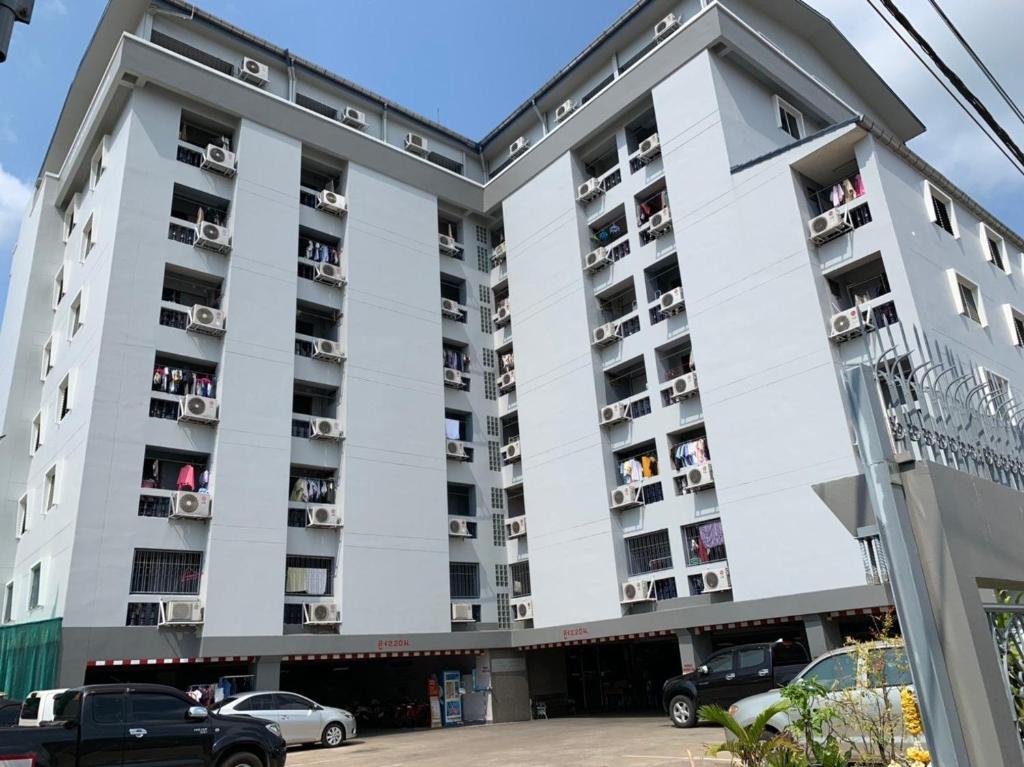 a large white apartment building with people in balconies at Prontip Place in Godown