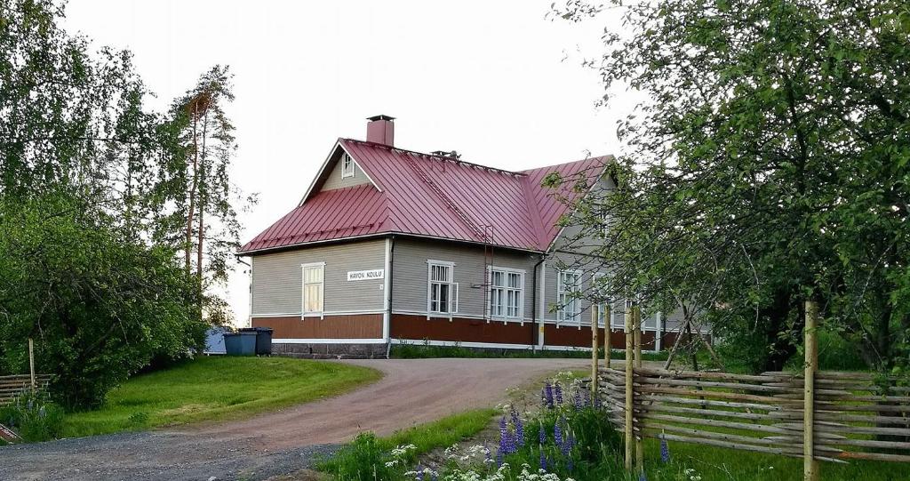 a house with a red roof and a dirt road at Wanha Havon Koulu yksiö in Savitaipale