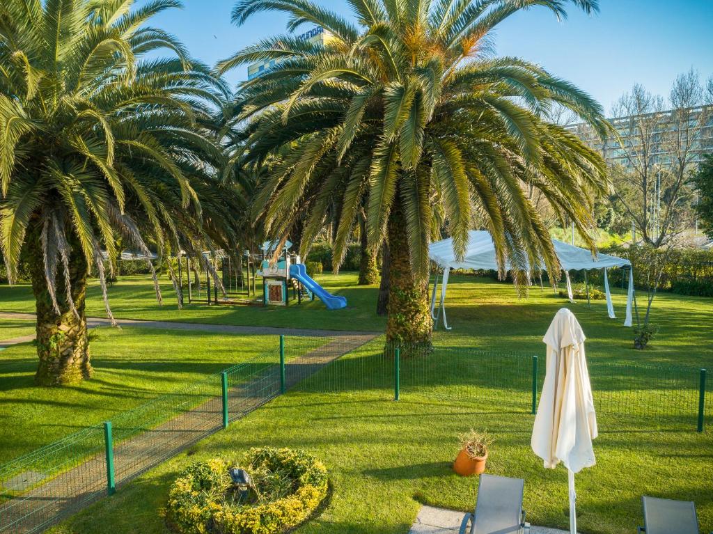 a park with palm trees and a playground at Novotel Porto Gaia in Vila Nova de Gaia