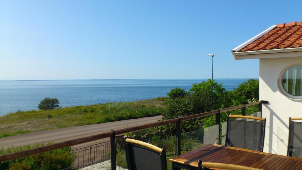a balcony with a table and a view of the ocean at Strandvillan, Öland - fantastiskt läge nära havet! in Löttorp