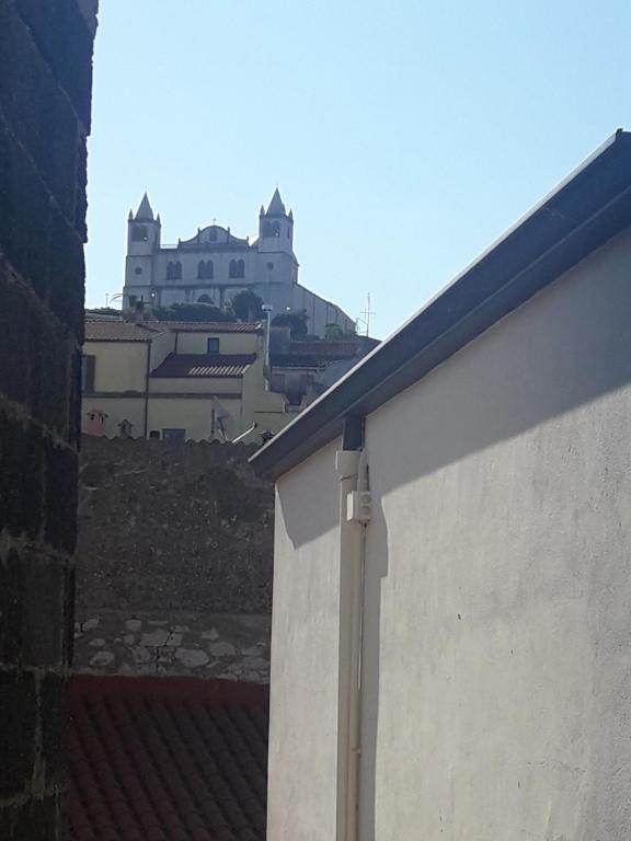 ein Gebäude auf einem Hügel mit einem Schloss im Hintergrund in der Unterkunft Casa Il Girasole in Cuglieri