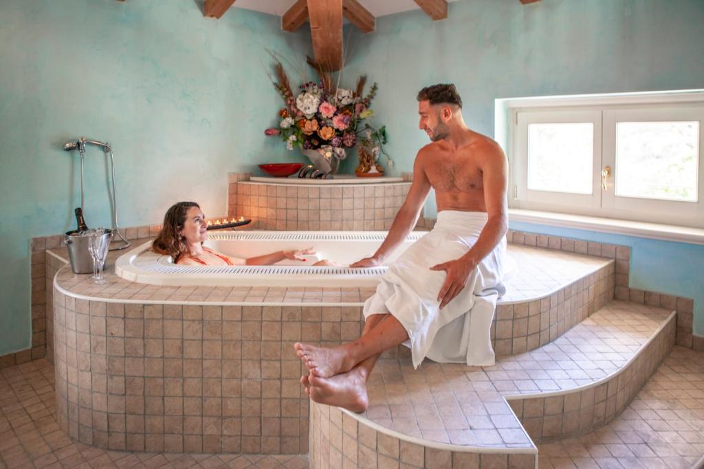 Ein Mann und eine Frau in einer Badewanne in der Unterkunft Hotel Olivo in Arco