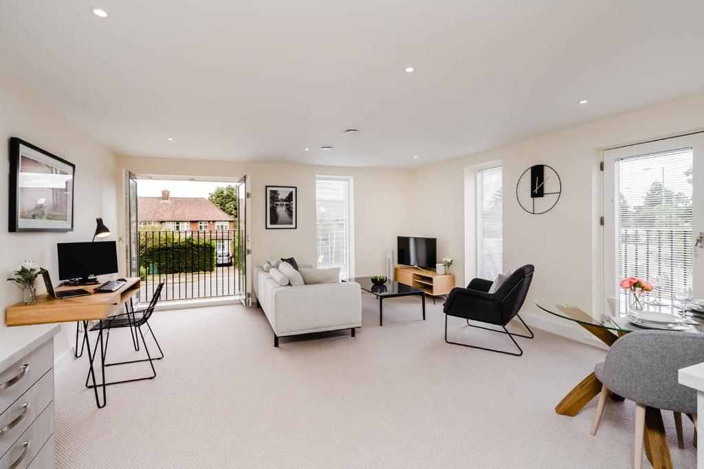 een woonkamer met een bank en een tafel en stoelen bij Tailored Stays - Lovell Lodge in Cambridge
