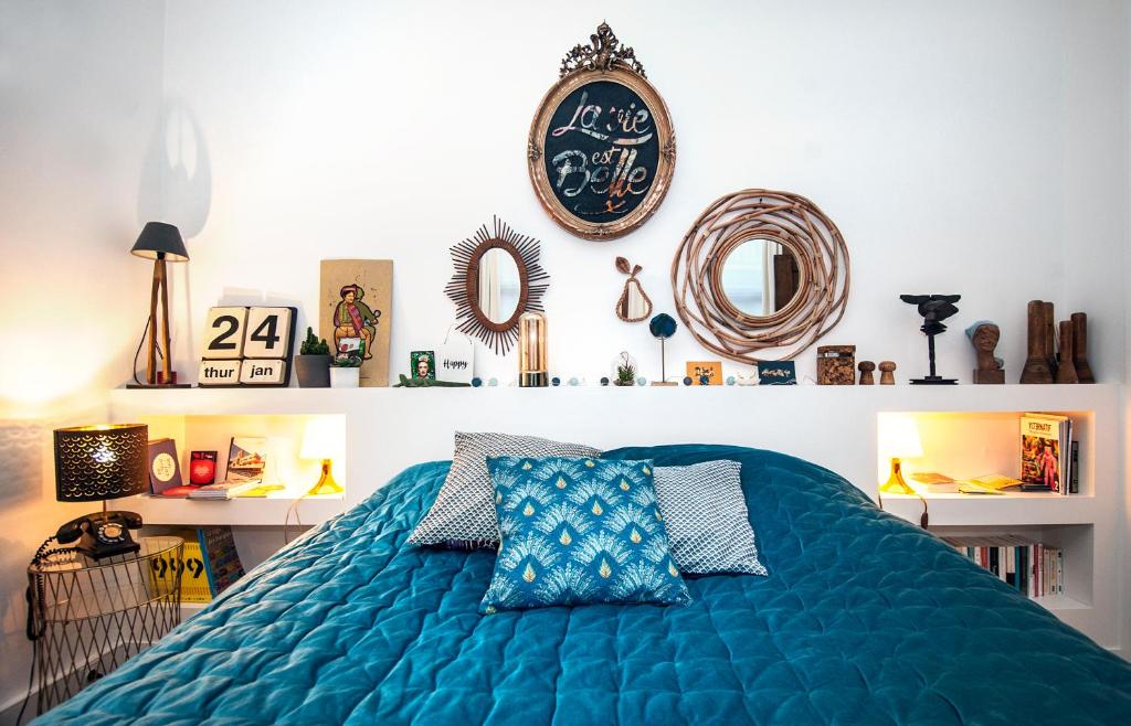 a bedroom with a blue bed with a clock on the wall at My Little Roubaix in Roubaix