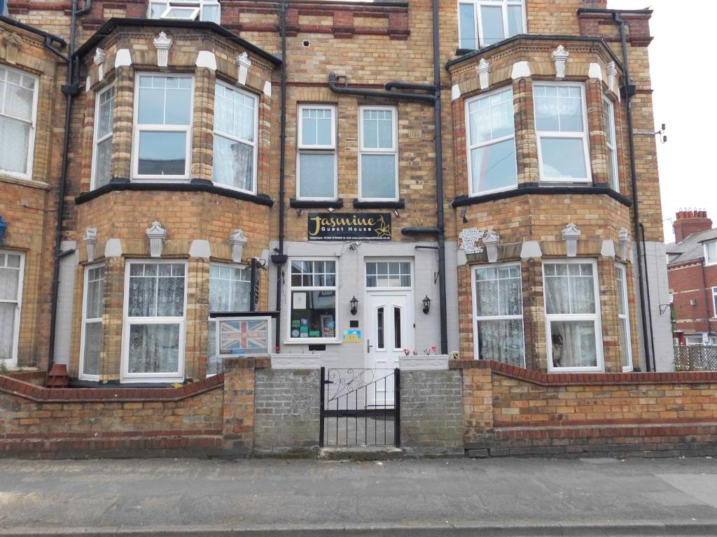 un edificio de ladrillo con un cartel en la parte delantera en Jasmine Guest House, en Bridlington