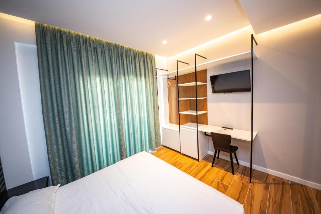 a hotel room with a bed and a desk at Inada Hotel Ksamil in Ksamil