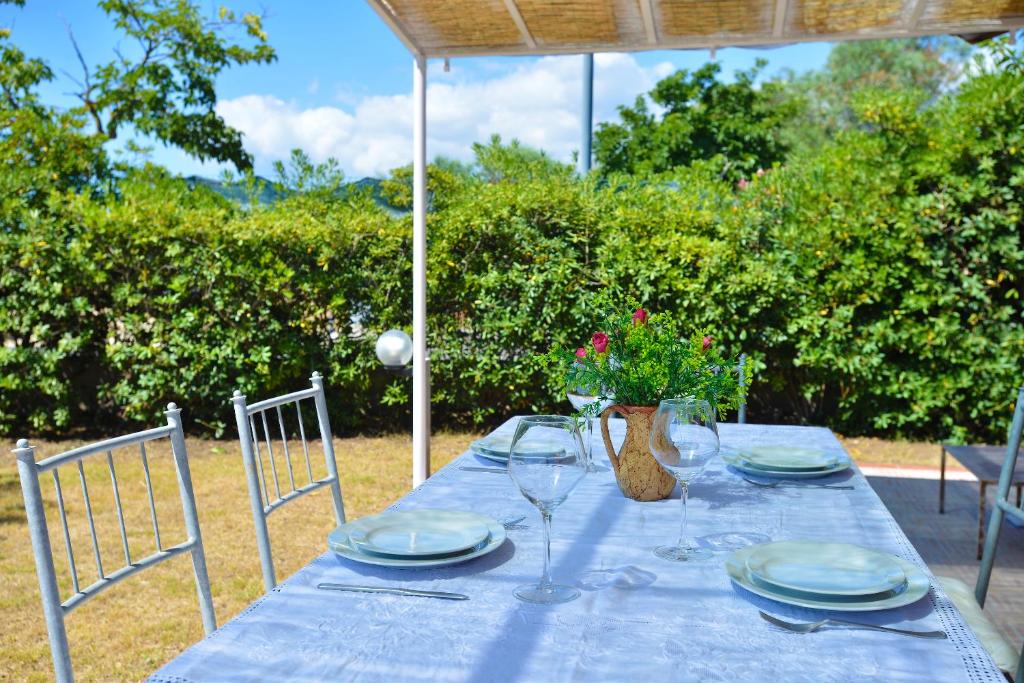 a blue table with plates and wine glasses on it at IzzHome Nora Beach in Pula
