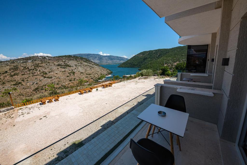 a balcony with a table and a view of a beach at Inada Hotel Ksamil in Ksamil