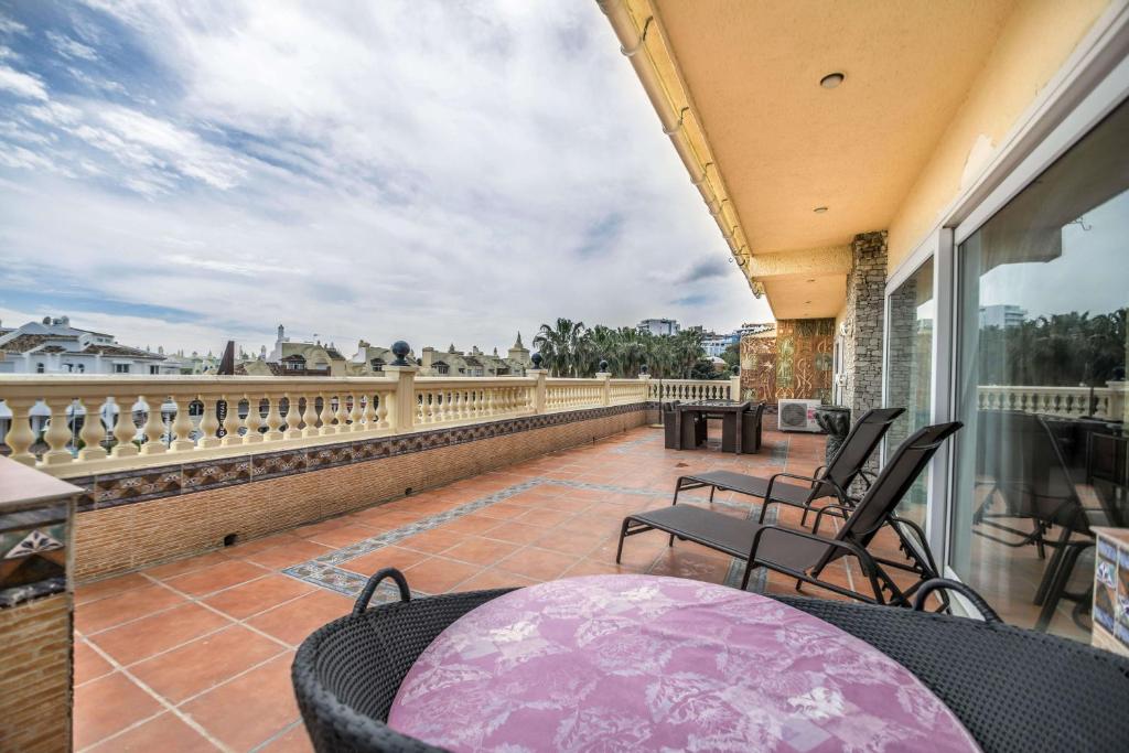 a balcony with chairs and a table on a balcony at Espectacular Atico en Puerto Marina in Benalmádena