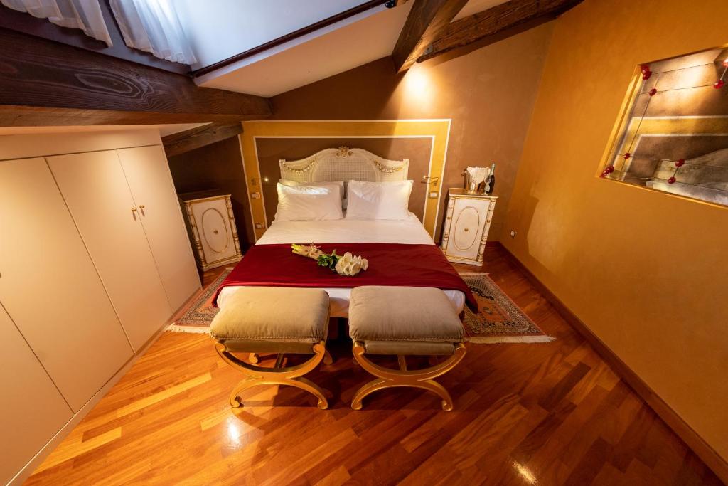 a bedroom with a large bed with two chairs at Cà dell'arte Suite in Venice