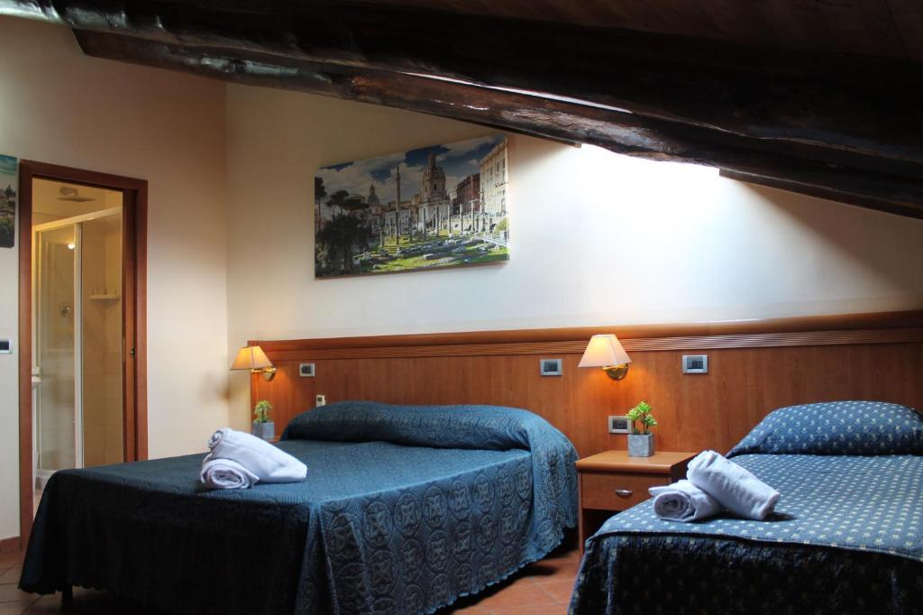 a bedroom with two beds and a painting on the wall at Nights In Rome in Rome