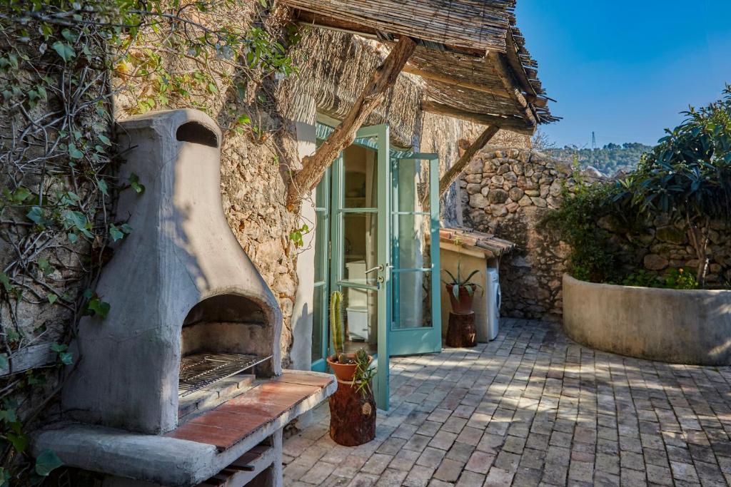 un edificio de piedra con un horno delante de él en Casa Marqués at Masia Nur Sitges, Adults only, en Canyelles