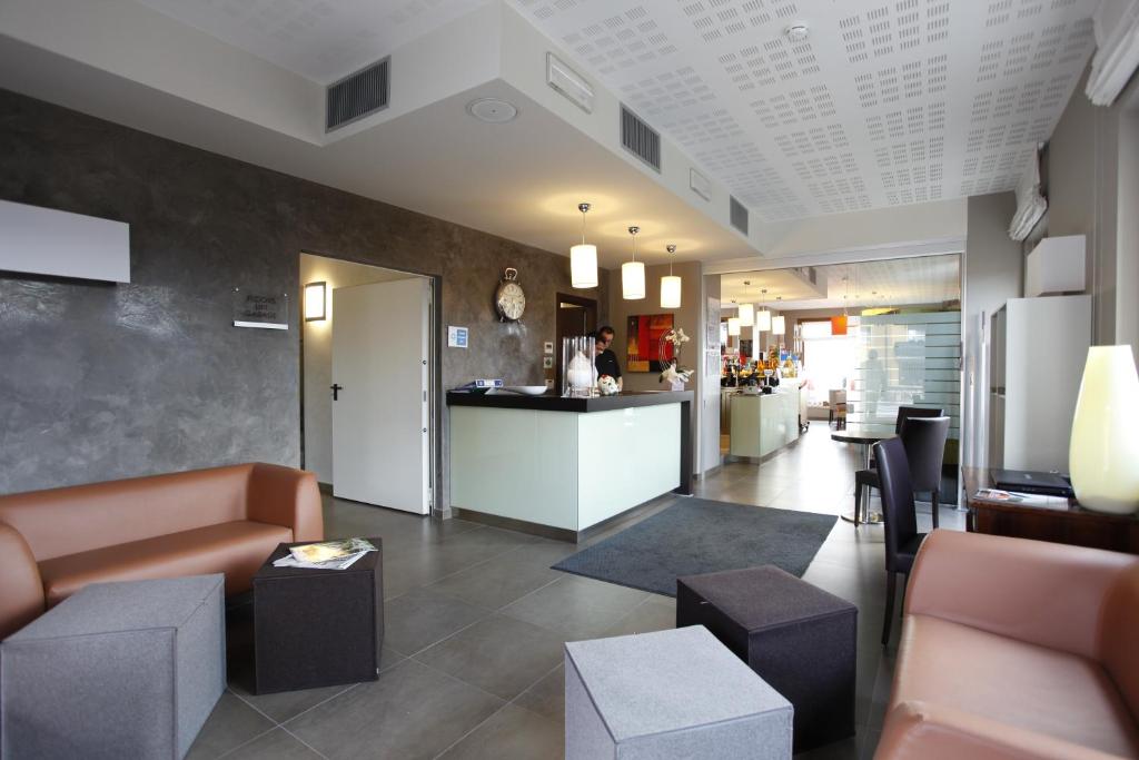 hol z kanapami i bar w budynku w obiekcie Hotel Lido w mieście Torri del Benaco