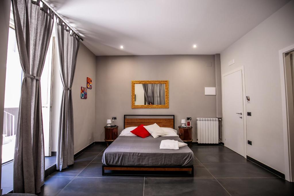 a bedroom with a bed and a mirror on the wall at Medusa Cilea Guest House in Naples